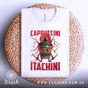 Футболка Itachini Cappuccini білого кольору, зображена на плетеній кошику, фон світлий, принт з кавовим стаканом та червоним текстом 'Cappuccini Itachini', футболка складена акуратно.