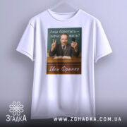 Футболка Іван Франко, біла, підвішена на вішалці, фон світло-сірий, принт з портретом Івана Франка, текст "Лиш боротись – значить жить!" на зеленому фоні, чоловік з бородою та вусами, тримає телефон і показує знак миру.