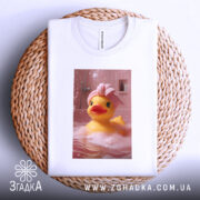 Футболка качка релакс, біла, зображення качки в рожевій ванні з піною, качка в рушнику на голові, складена на плетеній кошику, фон з рожевими плитками.