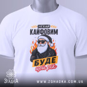 Футболка кайфовий новий рік, біла, зображена зверху, фон світло-сірий, принт з дідусем у чорній куртці, текст "НЕХАЙ КАЙФОВИМ БУДЕ ЦЕЙ РІК", на футболці є етикетка з зеленим шнурком.