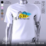 Футболка Карпати кличуть, біла, зображена на манекені, фон нейтральний, принт з горами, деревами та текстом на українській мові.