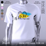 Футболка Карпати кличуть, біла, зображена на манекені, фон нейтральний, принт з горами, деревами та текстом на українській мові.