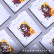 Футболка карта хаосу, біла, зображена на манекені, фон світло-сірий, принт з обличчям персонажа з картки, яскраві кольори жовтого та червоного, деталі обличчя виразні, текст "Доля Гра!".