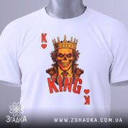 Футболка карта короля, біла, з верхнього ракурсу, на фоні світло-сірого градієнта, складена, принт з черепом у короні, червоний напис 'KING' та символи 'K' і серце, з етикеткою.