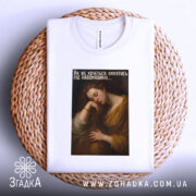 Футболка кава драматична, біла, складена на плетеній основі, фон світло-сірий, принт з жінкою, що спить, з текстом українською мовою.