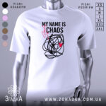 Футболка хаос настрій, біла, зображена на манекені, фон світло-сірий, принт чорний з червоним серцем та написом 'MY NAME IS CHAOS'.