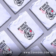 Футболка хаос настрій, біла, зображена на манекені, фон світло-сірий, принт чорний з червоним серцем та написом 'MY NAME IS CHAOS'.