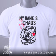 Футболка хаос настрій, біла, складена на поверхні, фон світло-сірий, принт чорний з червоним серцем та написом 'MY NAME IS CHAOS', видно етикетку з зеленим шнурком.
