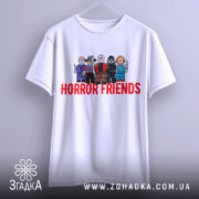 Футболка хорор друзі, біла, підвішена на вішалці, фон світло-сірий, принт з персонажами в стилі LEGO, текст 'HORROR FRIENDS' червоним кольором.