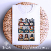 Футболка хорор класика, біла, зображена зверху на плетеній кошику, фон світлий, принт містить дев'ять персонажів з фільмів жахів, деталі принта яскраві, футболка акуратно складена.