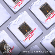 Футболка хвилина мовчання. Біла футболка з коротким рукавом, зображена з фронтального ракурсу на манекені. На грудях розташований принт з трьома солдатами, які стоять біля свічки, з текстом "ПАМ'ЯТЬ - ЗБРОЯ!" та червоним написом "Зупинись. Вшануй. Згадай."