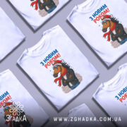 Футболка кінь з новим роком, біла, зображена з фронтального ракурсу на манекені, фон світло-сірий, принт з кінем у шапці та шарфі, напис 'З НОВИМ РОКОМ!' у верхній частині.