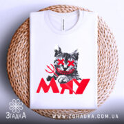 Футболка кіт-бунтар МЯУ, білого кольору, лежить на плоскій поверхні з плетеного матеріалу, фон світло-сірий. Принт з котом з червоними очима та усмішкою, тризуб у лапі, а під ним напис 'MAY' червоного кольору.