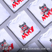 Футболка кіт-бунтар МЯУ, білого кольору, зображена на манекені з блискучою поверхнею, фон світло-сірий. Принт зображає кота з червоними очима та усмішкою, тримає тризуб, а під ним напис 'MAY' червоного кольору.