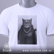 Футболка кіт гангстер стиль, біла футболка з принтом кота в гангстерському стилі, ракурс зверху, фон світло-сірий, принт зображує кота в капелюсі та з пістолетом, на шиї ланцюг, з етикеткою.