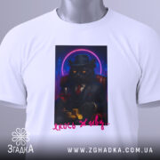 Футболка кіт якось живу, біла, зображена з верхнього ракурсу, на фоні світло-сірого градієнту, принт з котом у чорному костюмі, що тримає келих червоного вина та монети, з етикеткою на комірці.