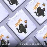 Футболка кіт мем, біла, зображена з фронтального ракурсу, фон нейтральний, принт з чорним котом, що піднімає лапу, з написом '-NOPE' жовтого кольору та короною.