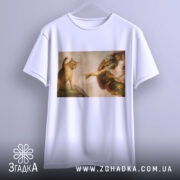 Футболка кіт Мікеланджело, біла, підвішена на вішалці, фон світло-сірий, принт з котом і людиною в стилі Мікеланджело, деталі малюнка чітко видимі.