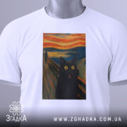 Футболка кіт стиль Мунка, біла, зображена на столі, фон світло-сірий, принт з чорним котом з великими жовтими очима, прикріплена етикетка з зеленим шнурком.