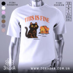 Футболка кіт this fine, біла футболка з принтом чорного кота, що сидить на фоні палаючого будинку, ракурс спереду, фон світлий, текст 'THIS IS FINE' виконаний оранжевим кольором.