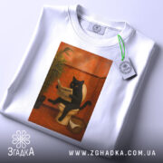 Футболка кіт вайб, біла футболка з принтом чорного кота на унітазі, ракурс зверху, фон світлий, деталі принта чітко видимі, є етикетка з зеленим шнурком.