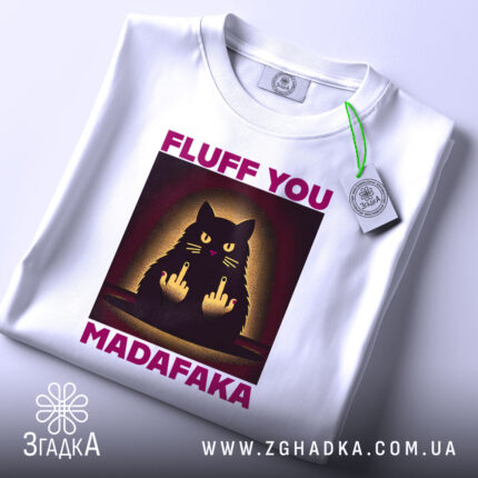 Футболка кіт з характером, біла, зображена зверху, фон світлий, принт з чорним котом, що показує два середніх пальці, текст 'FLUFF YOU MADAFAKA' у фіолетовому кольорі, на футболці є етикетка.