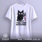 Футболка кіт з ножем, біла, підвішена на вішалці, фон градієнтний сірий, принт з чорним котом, що тримає ніж, текст "YOU SAW NOTHING" чорним шрифтом під котом.
