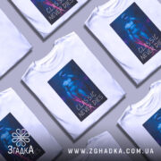 Футболка класика не вмирає, біла футболка з принтом, зображення статуї віртуальної реальності на темному фоні, яскраві кольори принта, акцент на деталях статуї.