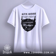 Футболка коханий чоловік, біла, зображена з фронтального ракурсу на манекені, фон світло-сірий, принт чорного кольору з написом 'Коханий чоловік і найкращий татусь в світі'.