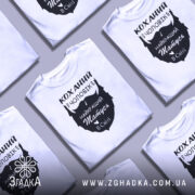 Футболка коханий чоловік, біла, зображена з фронтального ракурсу на манекені, фон світло-сірий, принт чорного кольору з написом 'Коханий чоловік і найкращий татусь в світі'.