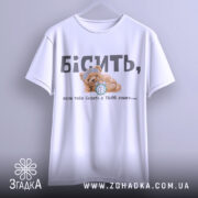 Футболка коли тебе будять, біла футболка, підвішена на вішалці, ведмедик з годинником на принті, ракурс спереду, фон світлий, текст на футболці чорний і сірий.