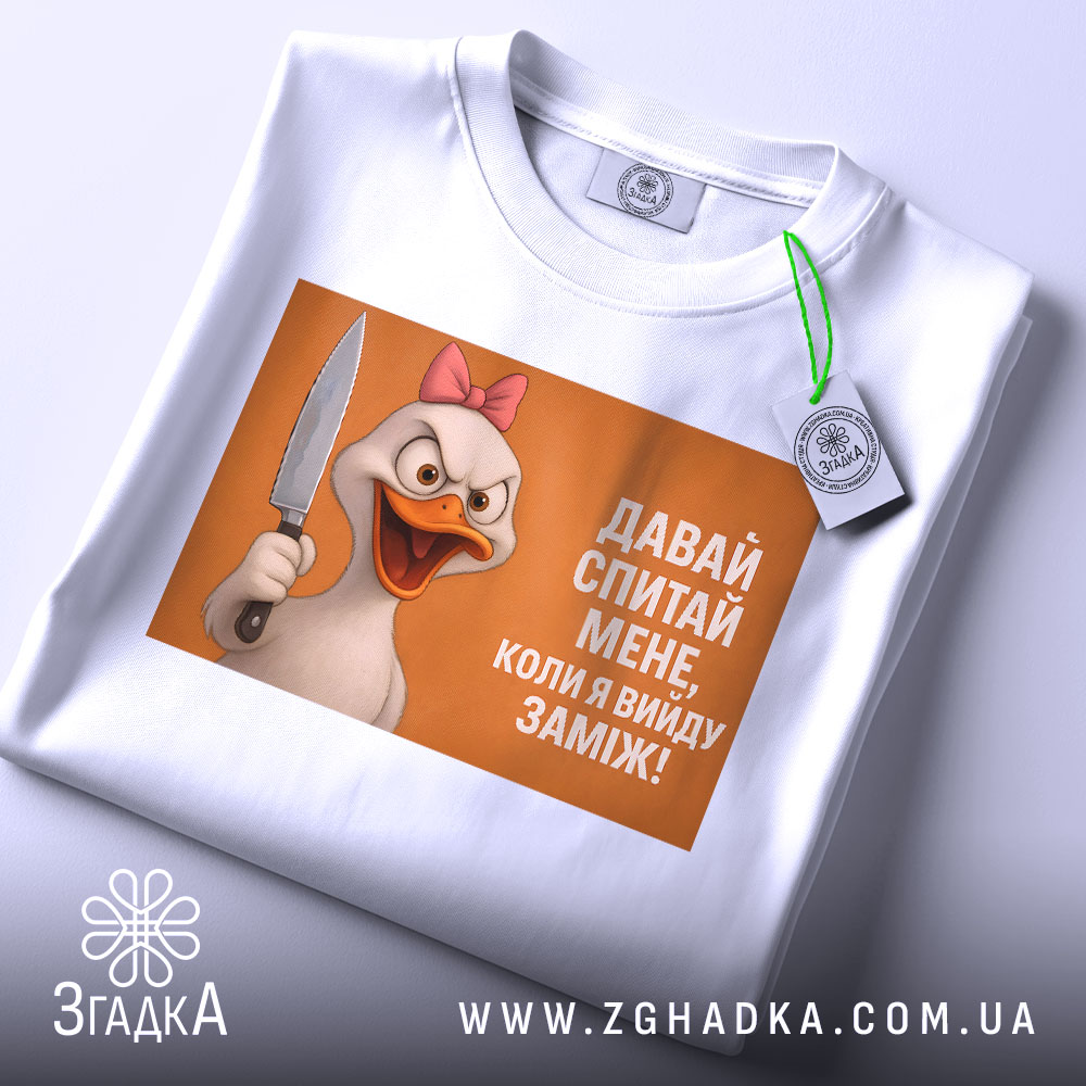 Футболка коли вийду заміж, біла, зображена зверху, фон світлий, принт з качкою з рожевим бантом, яка тримає ніж, текст на принті: 'ДАВАЙ СПИТАЙ МЕНЕ, КОЛИ Я ВИЙДУ ЗАМІЖ!', на футболці є етикетка з зеленим шнурком.