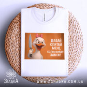 Футболка коли вийду заміж, біла, зображена зверху на плетеній кошику, фон світлий, принт з качкою з рожевим бантом, яка тримає ніж, текст на принті: 'ДАВАЙ СПИТАЙ МЕНЕ, КОЛИ Я ВИЙДУ ЗАМІЖ!'