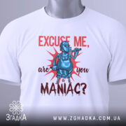 Футболка комічний маніяк, біла, складена на поверхні, фон світло-сірий, принт з персонажем у масці, що тримає трубку, текст червоним кольором, з етикеткою на рукаві.