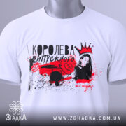 Футболка королева випускного, білого кольору, зображена зверху, на ній видно етикетку з зеленим шнурком, фон світло-сірий, принт червоно-чорний з зображенням дівчини.