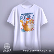 Футболка котани з новим роком, біла, зображена на вішалці, фон світло-сірий, принт з котом у червоній шапці та сердечками.