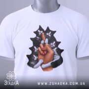 Футболка котяча любов, біла, складена на столі, фон світлий, принт зображає руку з манікюром, що тримає кілька чорних котів, коти з виразами радості, на футболці є етикетка.