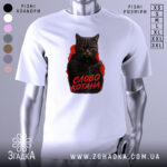 Футболка котяча мафія, біла футболка на манекені, фон світло-сірий, принт з котом у чорному капюшоні з пістолетом, текст 'СЛОВО КОТАНА' червоним кольором.