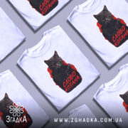 Футболка котяча мафія, біла футболка на манекені, фон світло-сірий, принт з котом у чорному капюшоні з пістолетом, текст 'СЛОВО КОТАНА' червоним кольором.