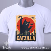 Футболка котяча монстр білого кольору, зображена зверху, на фоні світло-сірого, принт з чорним котом, що піднімає лапу на фоні червоного сонця, з зеленим ярликом.