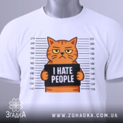 Футболка котячий гумор хейт, складена біла футболка з принтом кота, що тримає табличку з написом 'I HATE PEOPLE', фон світло-сірий, видно етикетку з логотипом, принт чіткий і кольоровий.