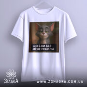 Футболка котячий настрій, біла, зображена на вішалці, фон світло-сірий, принт з котом з усмішкою та текстом "ЩО Б ВИ БЕЗ МЕНЕ РОБИЛИ" на чорному фоні.