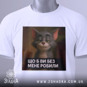 Футболка котячий настрій, біла, зображена зверху, фон світло-сірий, принт з котом з усмішкою та текстом "ЩО Б ВИ БЕЗ МЕНЕ РОБИЛИ", на футболці підвішений етикет.