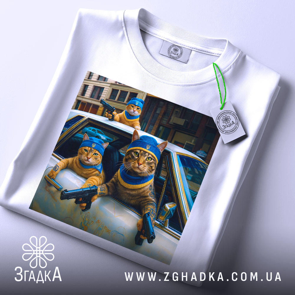 Футболка коти банда, біла футболка з принтом, ракурс зверху, фон світлий, на принті три коти в блакитних капелюшках, один з них тримає пістолет.