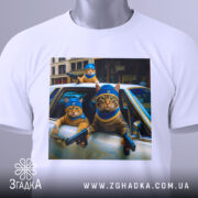 Футболка коти банда, біла футболка з принтом, ракурс зверху, фон світлий, на принті три коти в блакитних капелюшках, один з них тримає пістолет.