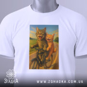 Футболка коти на велосипедi, біла, зображена зверху, на фоні світло-сірого градієнту, принт з двома котами на велосипеді, один сірий, інший рудий, обидва з усмішками, на фоні зеленого пейзажу, з етикеткою на комірці.