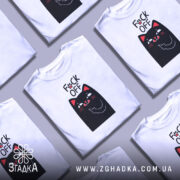 Футболка котик фак офф, біла футболка на манекені, з принтом чорного кота, який показує середній палець, фон світло-сірий, принт яскравий з червоними деталями.