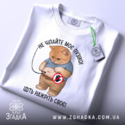 Футболка котик пузіко, біла футболка, зображення кота з округлим животом у синій футболці, ракурс зверху, фон світло-сірий, принт з текстом "НЕ ЧИПАЙТЕ МОЄ ПУЗІКО! ІДІТЬ НАЖРІТЬ СВОЄ!", на футболці є етикетка.