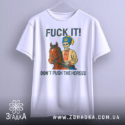 Футболка козак не жени. Біла футболка, підвішена на вішалці, з принтом, що зображує скелета в українському вбранні на коні. На фоні світло-сірий градієнт. Текст на футболці: 'FUCK IT! DON'T PUSH THE HORSES'.