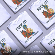 Футболка козак не жени. Біла футболка на манекені, з принтом, що зображує скелета в українському вбранні, який сидить на коні. На фоні світло-сірий градієнт. Текст на футболці: 'FUCK IT! DON'T PUSH THE HORSES'.